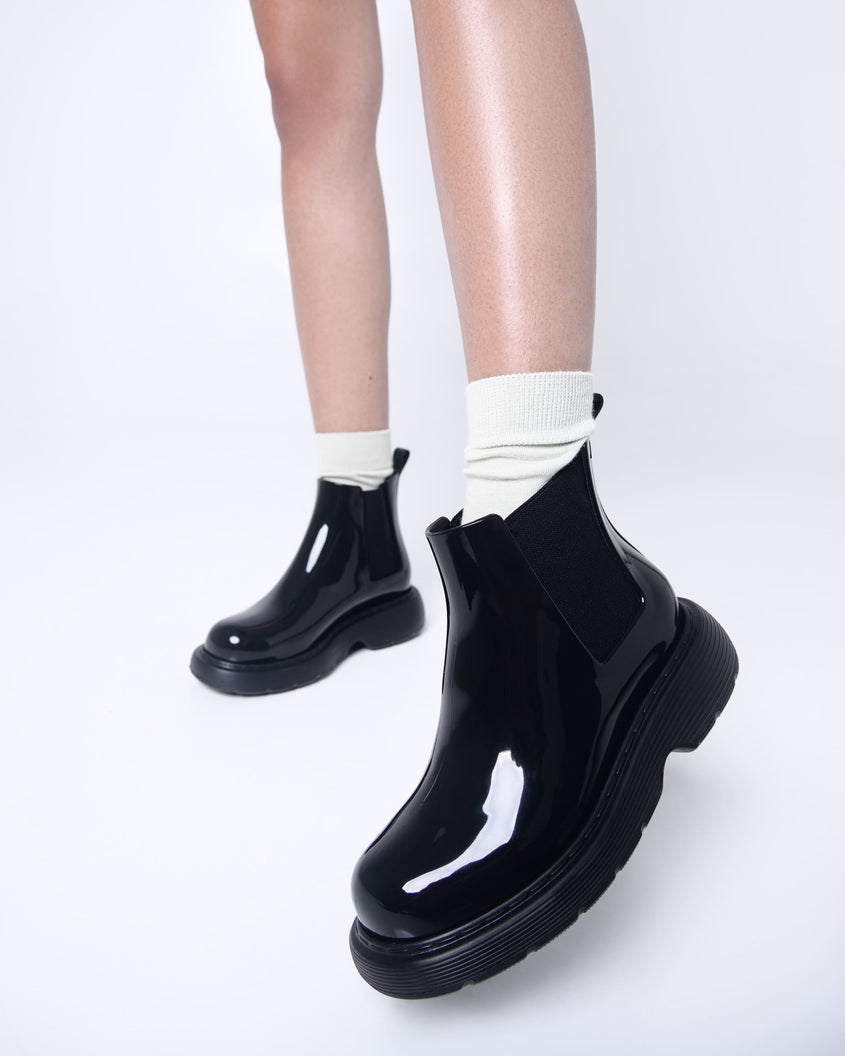 Models legs wearing a pair of black Melissa Step boots.
