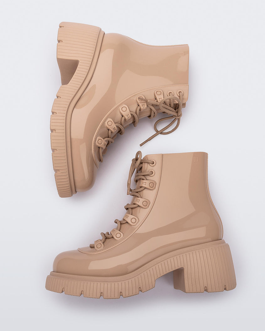 Side view of a pair of a beige Melissa Cosmo boots.