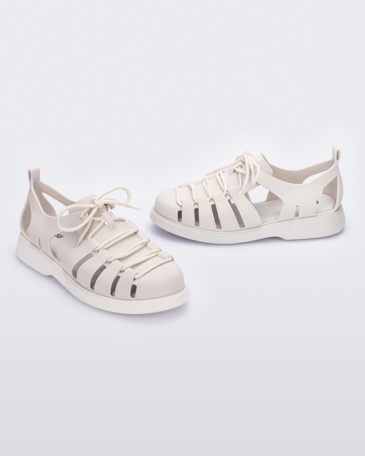 Side and angled view of a pair of white Match sneaker sandals