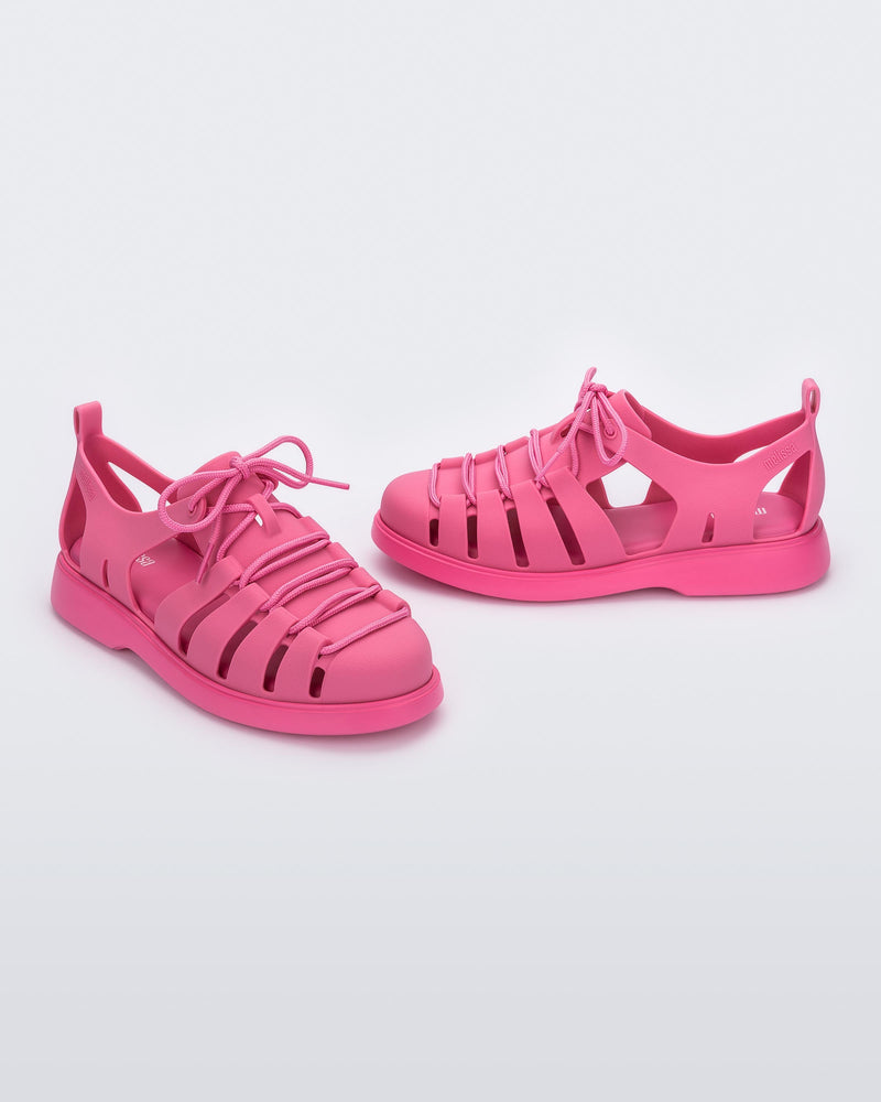 Side and angled view of a pair of pink Match sneaker sandals