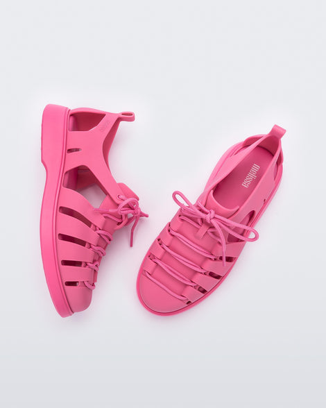 Side and top view of a pair of pink Match sneaker sandals
