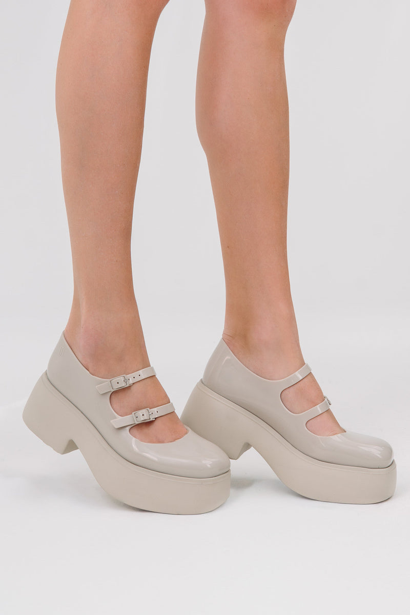 Model's legs wearing a pair of beige Farrah platform mary janes