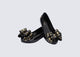 Angled view of a pair of black Ultragirl Sweet X kids flats with a bow that has chrome flowers on it