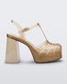 Side view of a beige glitter gold Melissa Party platform heel. 