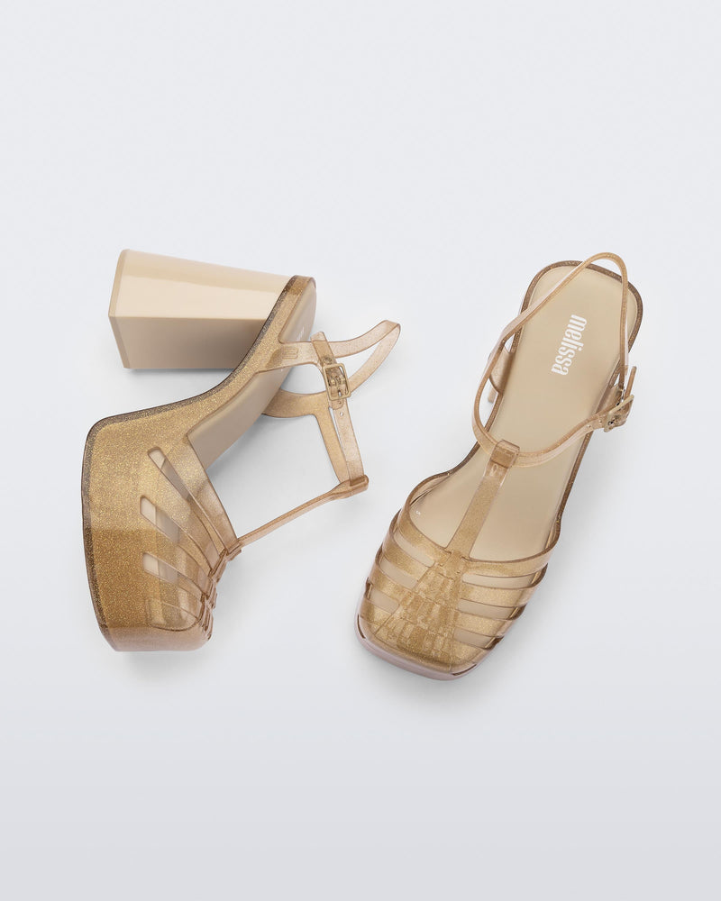 Side and top view of a pair of beige glitter gold Melissa Party platform heel. 