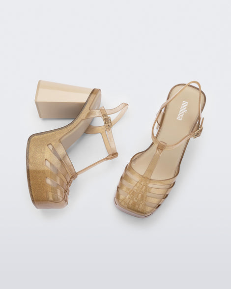 Side and top view of a pair of beige glitter gold Melissa Party platform heel. 
