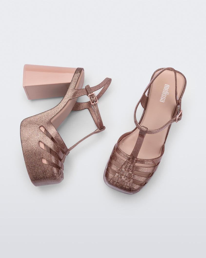 Side and top view of a pair of pink glitter Melissa Party platform heels. 