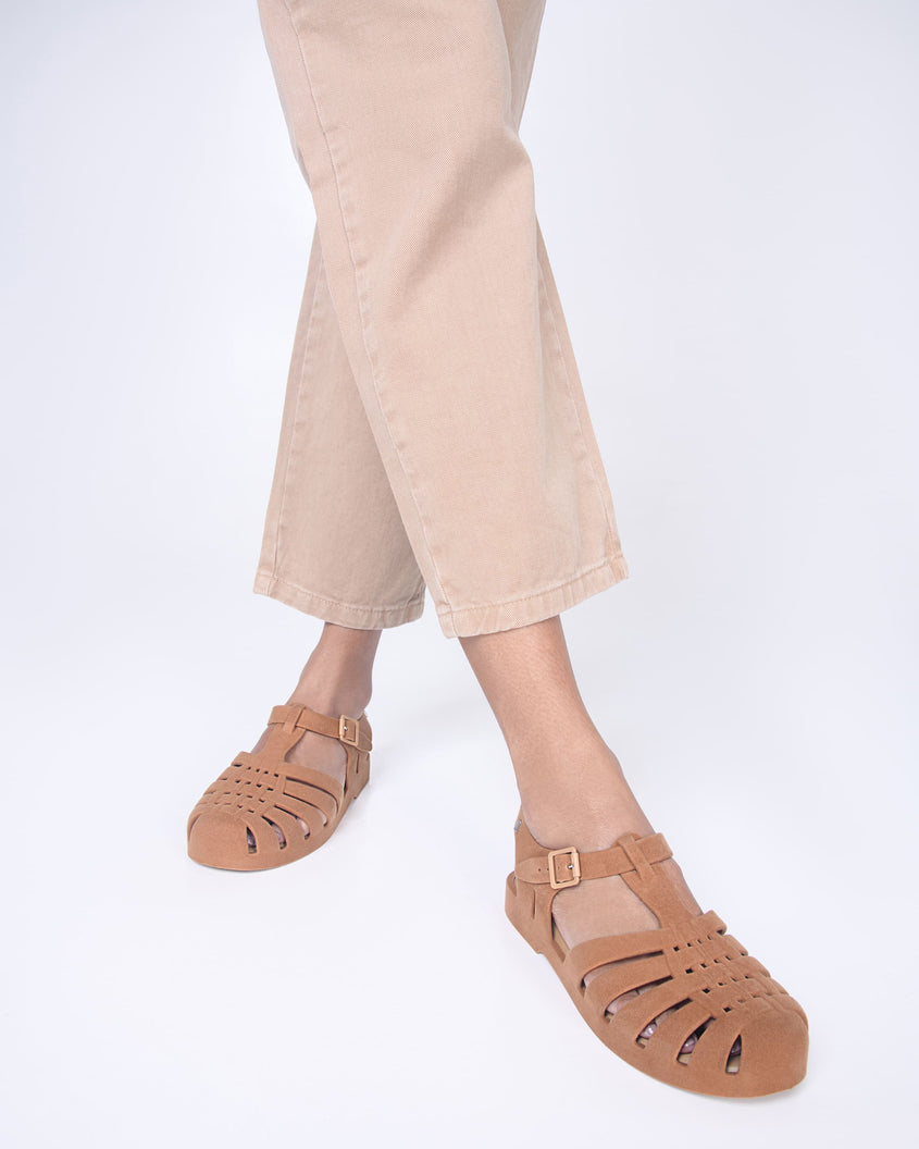Model's legs wearing a pair beige flocked Melissa Possession Velvet sandals.