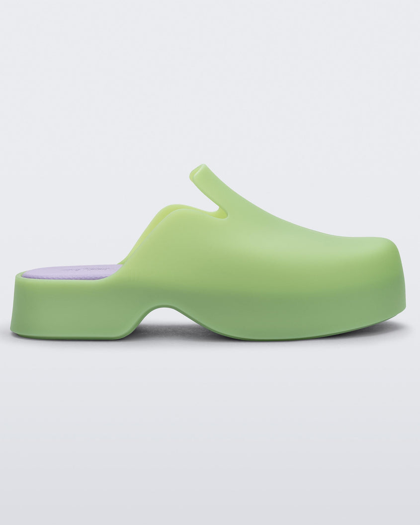 Side view of a green Melissa Zoe mule with purple insole.