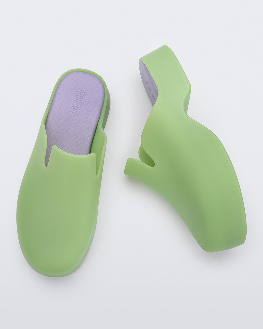 Top and side view of a pair of green Melissa Zoe mules with purple insoles.