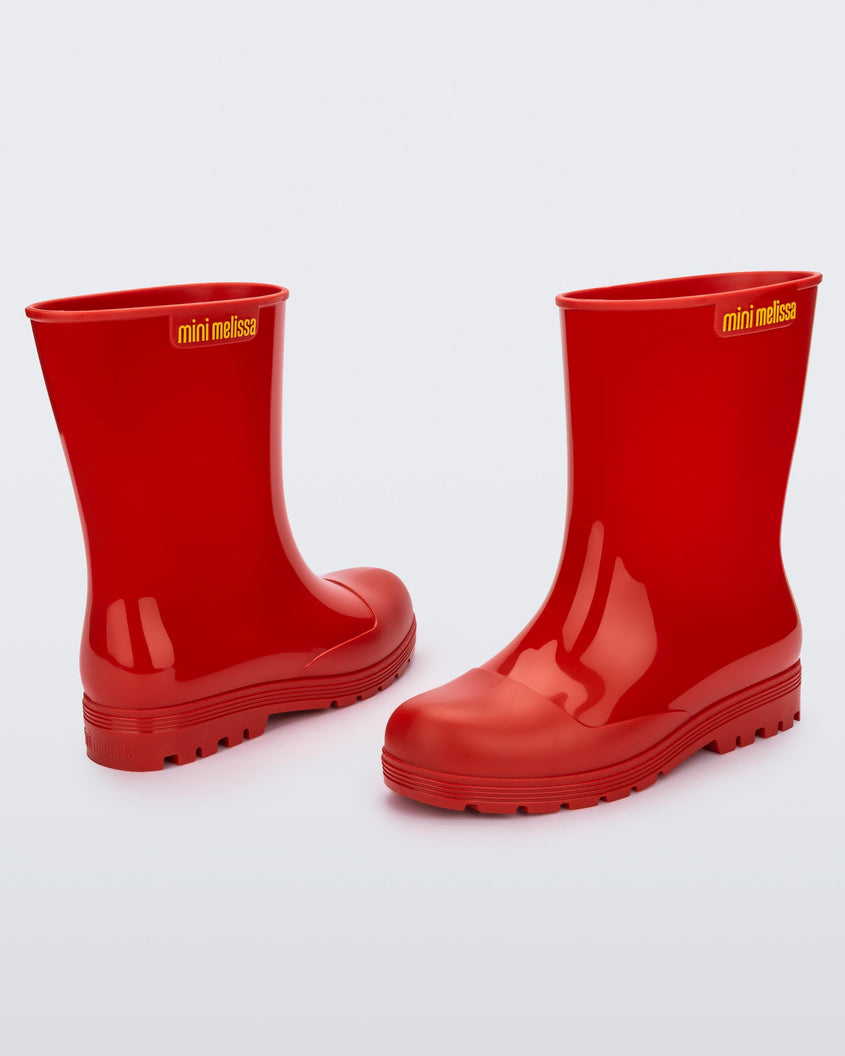 Angled view of a pair of red kids Melissa Welly boots.