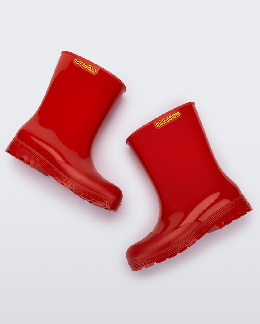 Side view of a pair of red kids Melissa Welly boots.