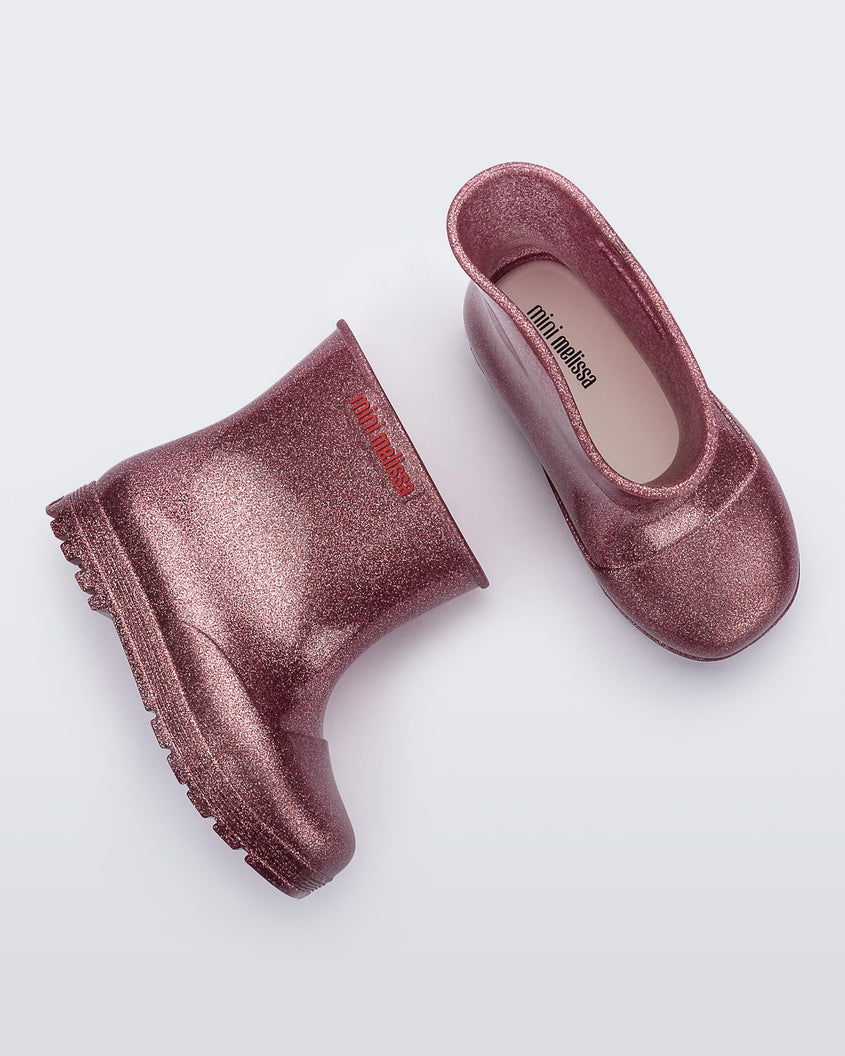 Top and side view of a pair of glitter pink baby Melissa Welly boots.