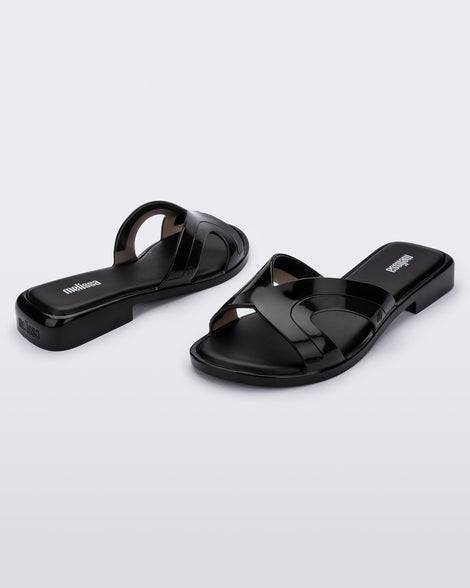 Angled front and back view of a pair of black Melissa Yacht slides.
