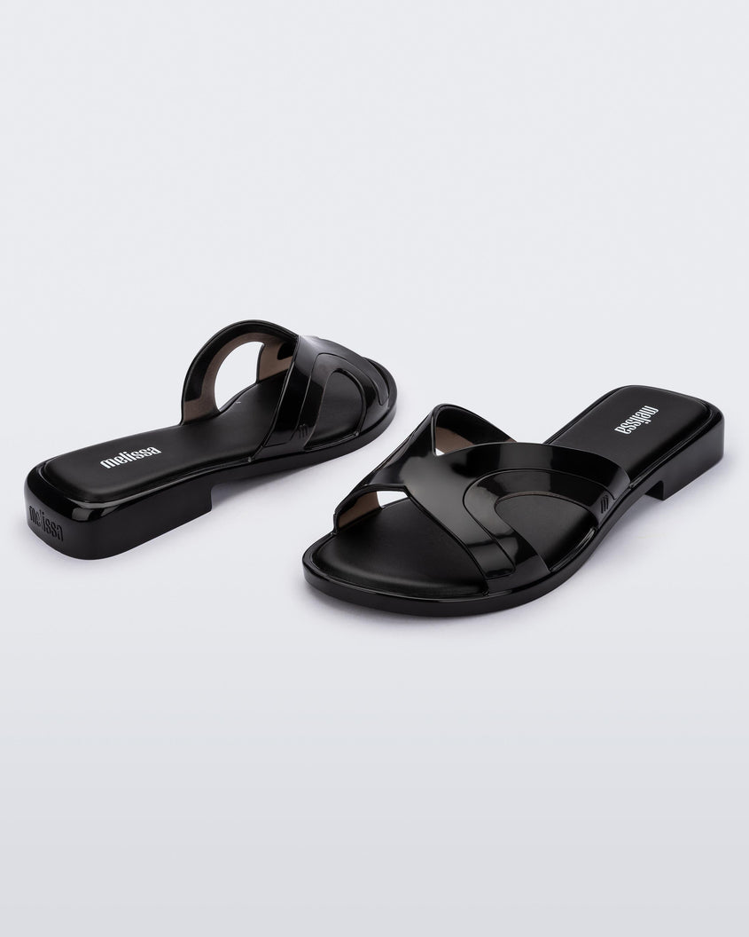 Angled front and back view of a pair of black Melissa Yacht slides.