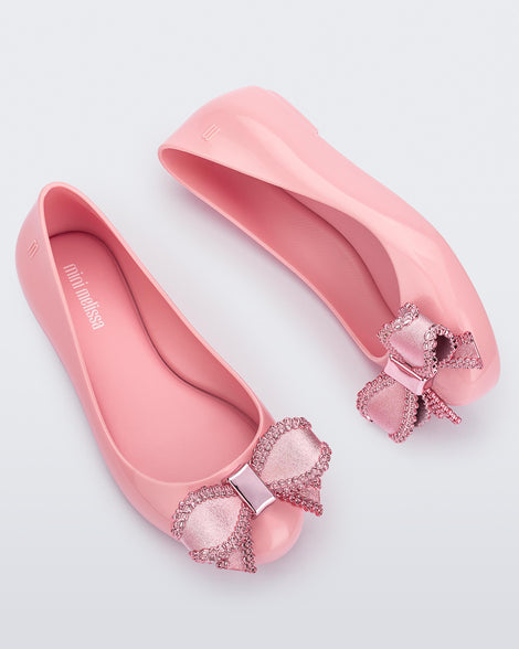Side and angled view of a pair of pink Mini Melissa Sweet Love kids flats with metallic pink bow.