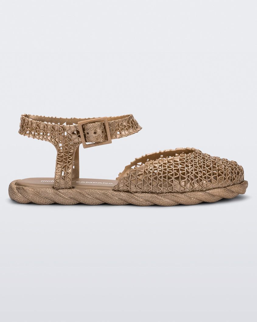 Side view of a gold Melissa Papel Espadrille Campana sandal with braided sole detail and ankle strap