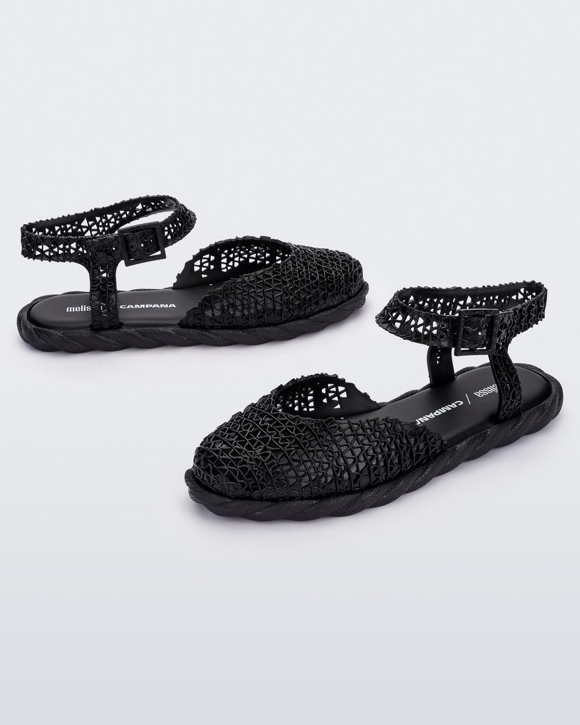 Side and angled view of a pair of black Melissa Papel Espadrille Campana sandals with braided sole detail and ankle strap