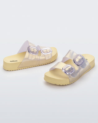 Front and back angled view of a pair of pearly yellow Cozy slides with two buckles.