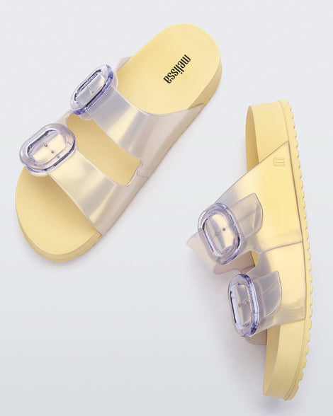 A top and side view of a pair of pearly yellow Melissa Cozy slides