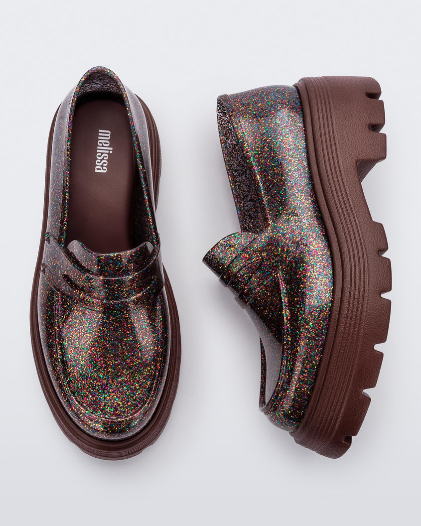 Top and side view of a pair of  Melissa Royal loafers in glitter multicolor with a brown platform sole.