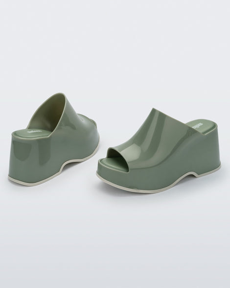 Back and angled view of a pair of light green Patty mule platforms.