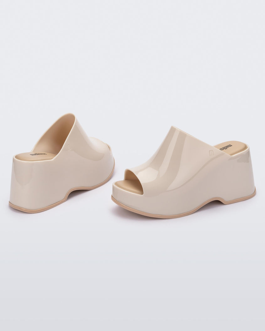 Angled view of a pair of beige Melissa Patty platform mules.