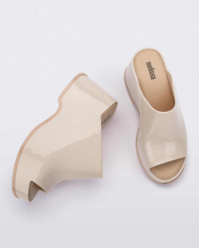 Top and side view of a pair of beige Melissa Patty platform mules.