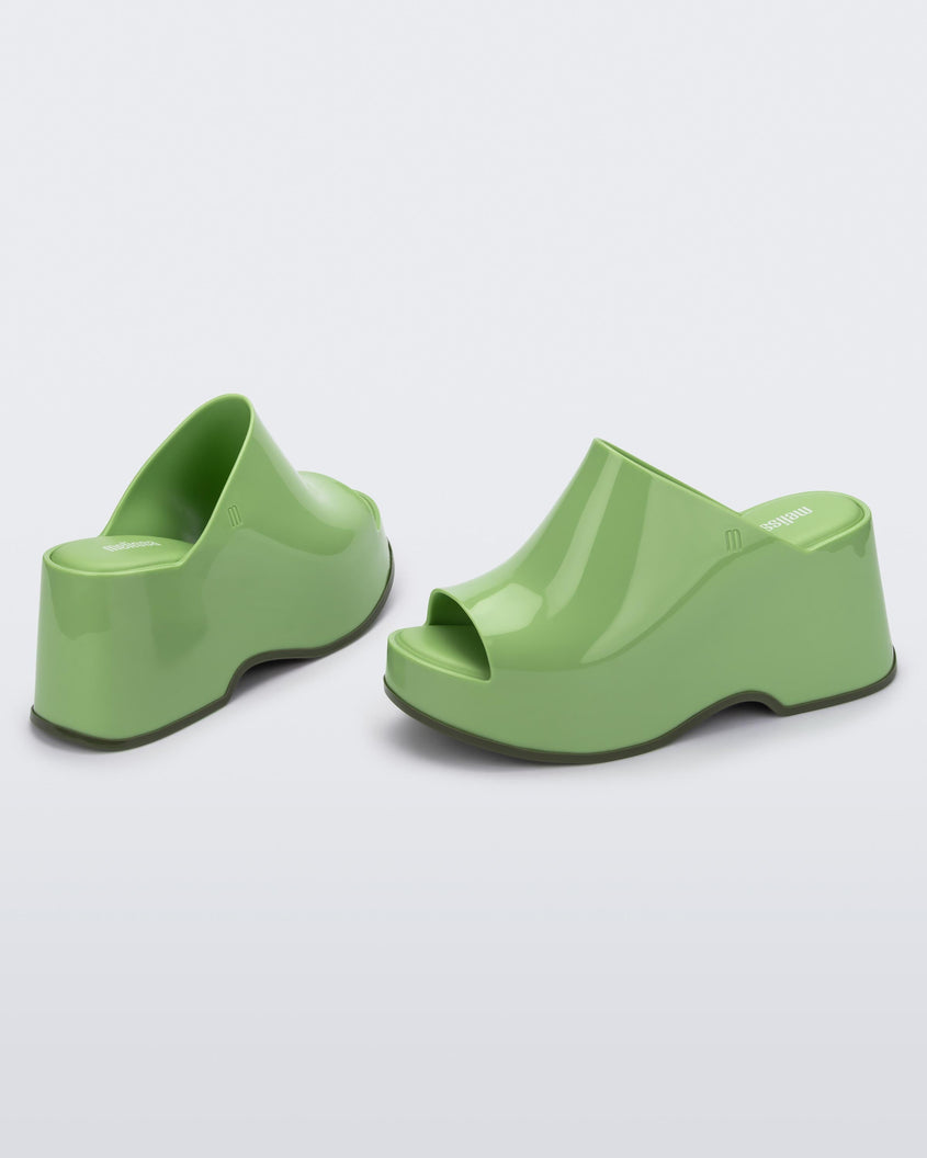 Angled view of a pair of green Melissa Patty platform mules.