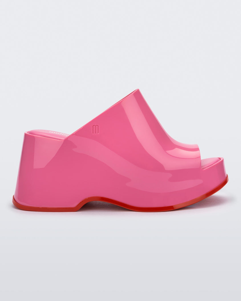 Side view of a pink Melissa Patty platform mule with red outsole.