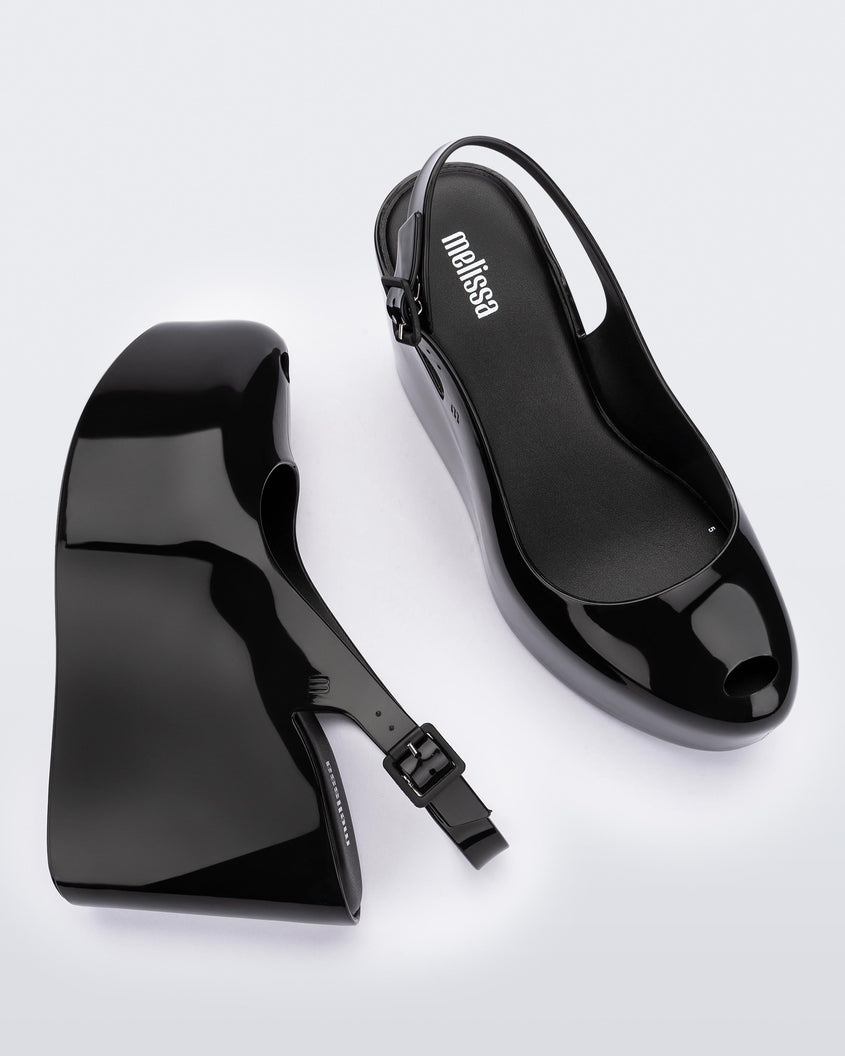 Side and top view of a pair of black Melissa Groovy wedge platform slingback heels with peep toe.