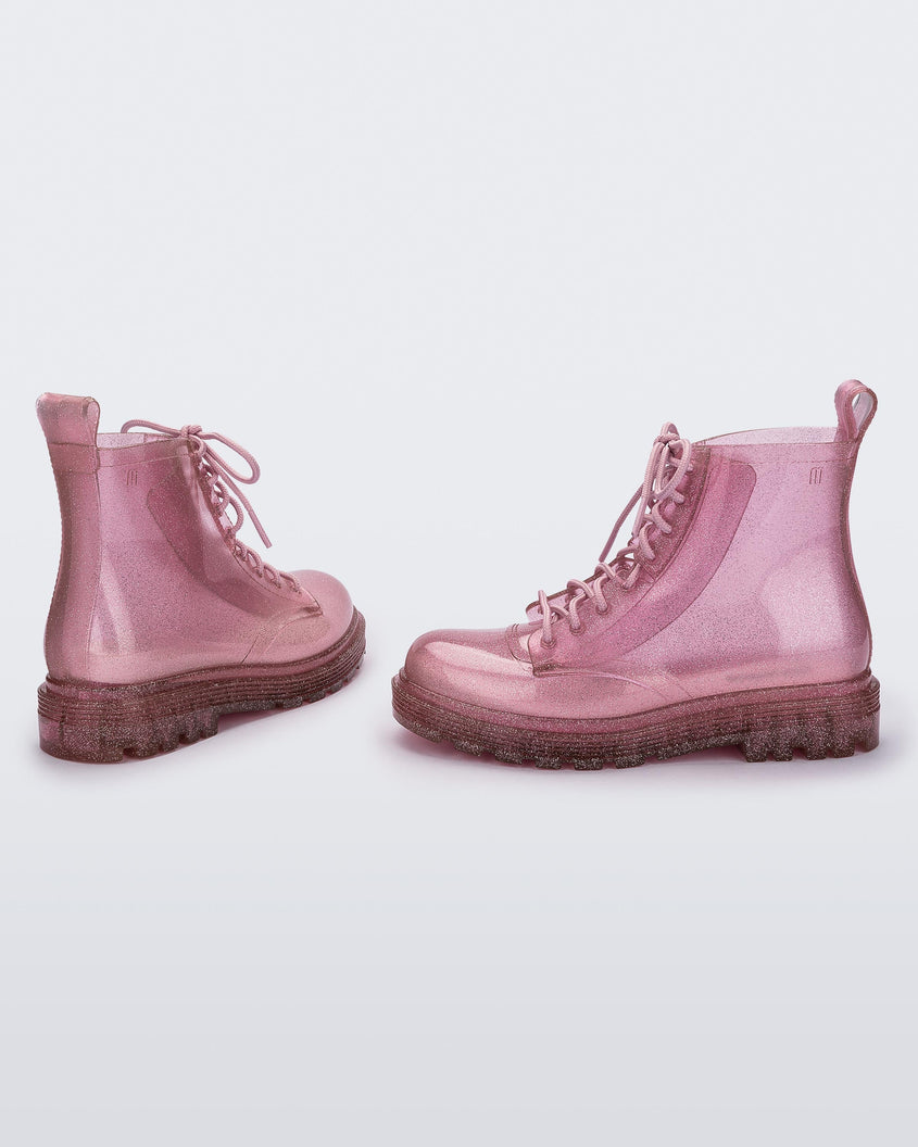Angled view of a pair of glitter pink kids Melissa Coturno boots.