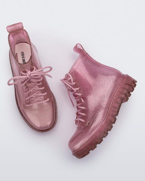 Top and side view of a pair of glitter pink kids Melissa Coturno boots.