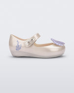 Side view of a pearly white Mini Melissa Ultragirl + Disney Little Mermaid flat with a pearly blue shell on top