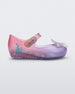 Side view of a transparent pink and purple Mini Melissa Ultragirl + Disney Little Mermaid flat with a pearly white flower on top