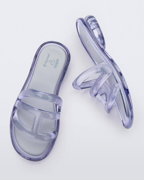 Top and side view of a pair of Melissa Jelly Slides in Clear with white insole.