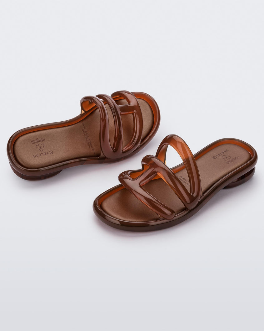 Top angled view of a pair of Melissa Jelly Slides + Telfar in brown.