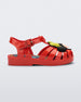 Side view of a red Mini Melissa Possession + Disney 100 sandal with Mickey on one foot and Minnie on another foot.