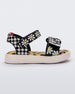 Side view of a white, black and yellow patterned Mini Melissa Pula Pula + Fabula sandal.