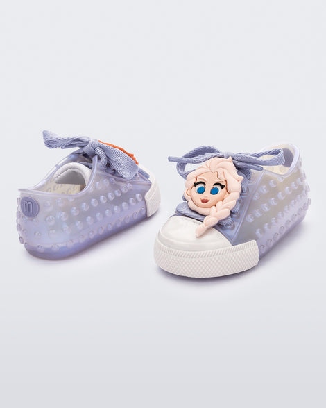 Angled view of a pair of baby metallic blue Melissa Polibolha Disney sneakers with a white toe top with Disney Frozen's  Anna and Elsa.