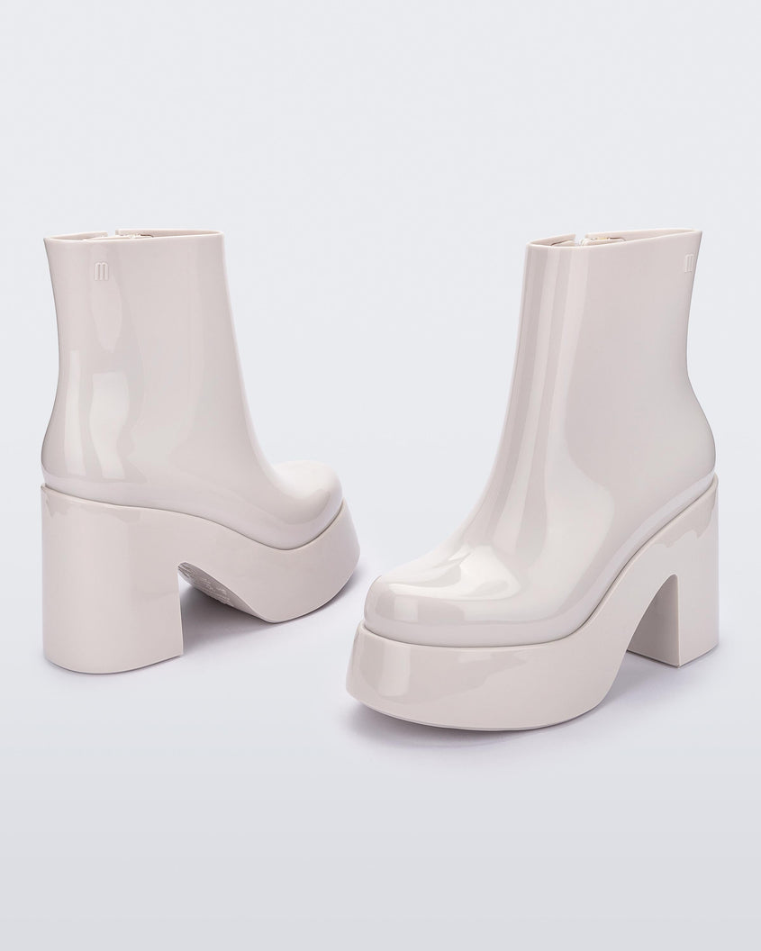 Angled and back view of a pair of white Melissa Nubia  platform heel boots.