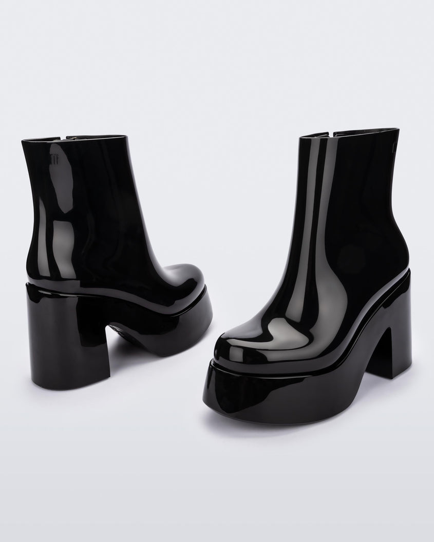 Angled and back view of a pair of black Melissa Nubia  platform heel boots.