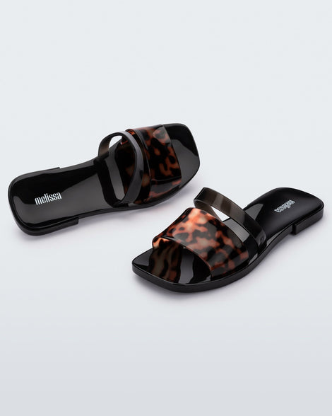 Angled view of a pair of black and tortoise Ivy women's slide