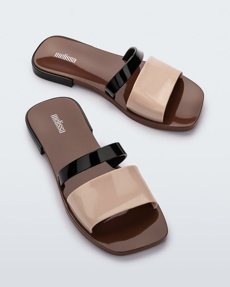 Angled view of a pair of black, brown, and beige Ivy women's slide.
