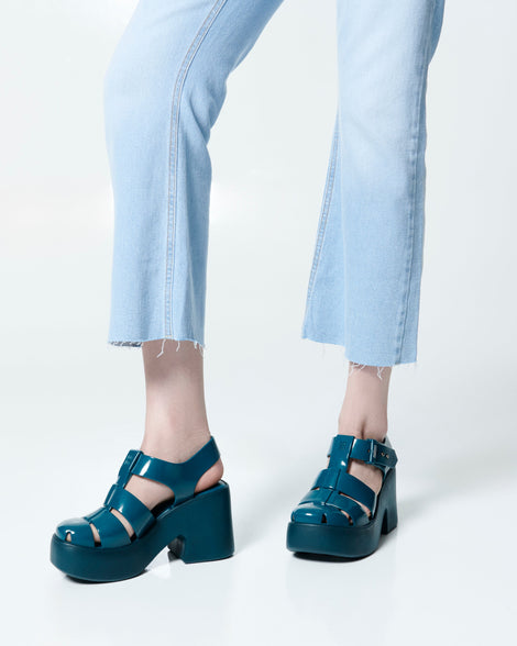 Model's legs in a pair of blue Lulu platform heel fisherman sandals