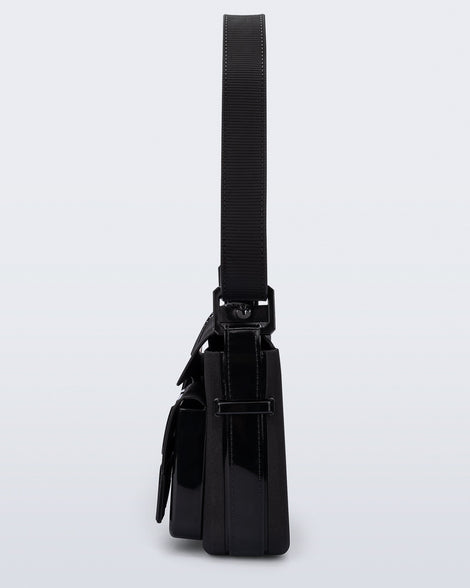 Side view of a black Cargo bag with two small pockets on the front and an adjustable strap