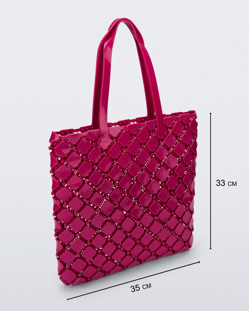 Angled view of a pink Melissa Mogu  + Hikaru Matsumura bag with dimensions 35 cm length and 33 cm height