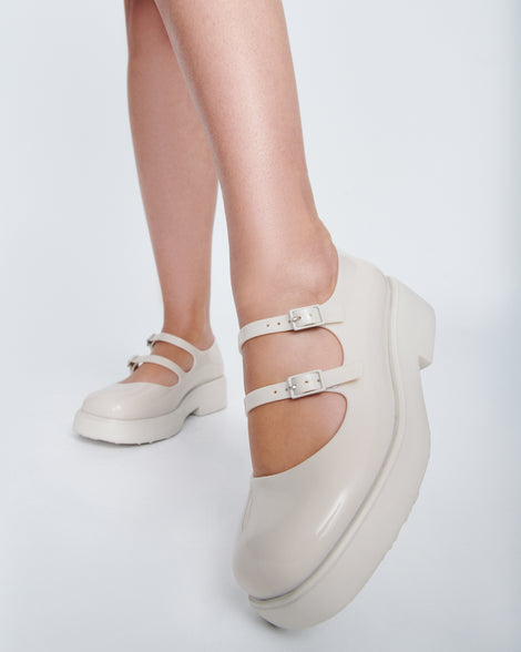 Model's legs wearing a pair of beige Farah Low Mary jane loafers