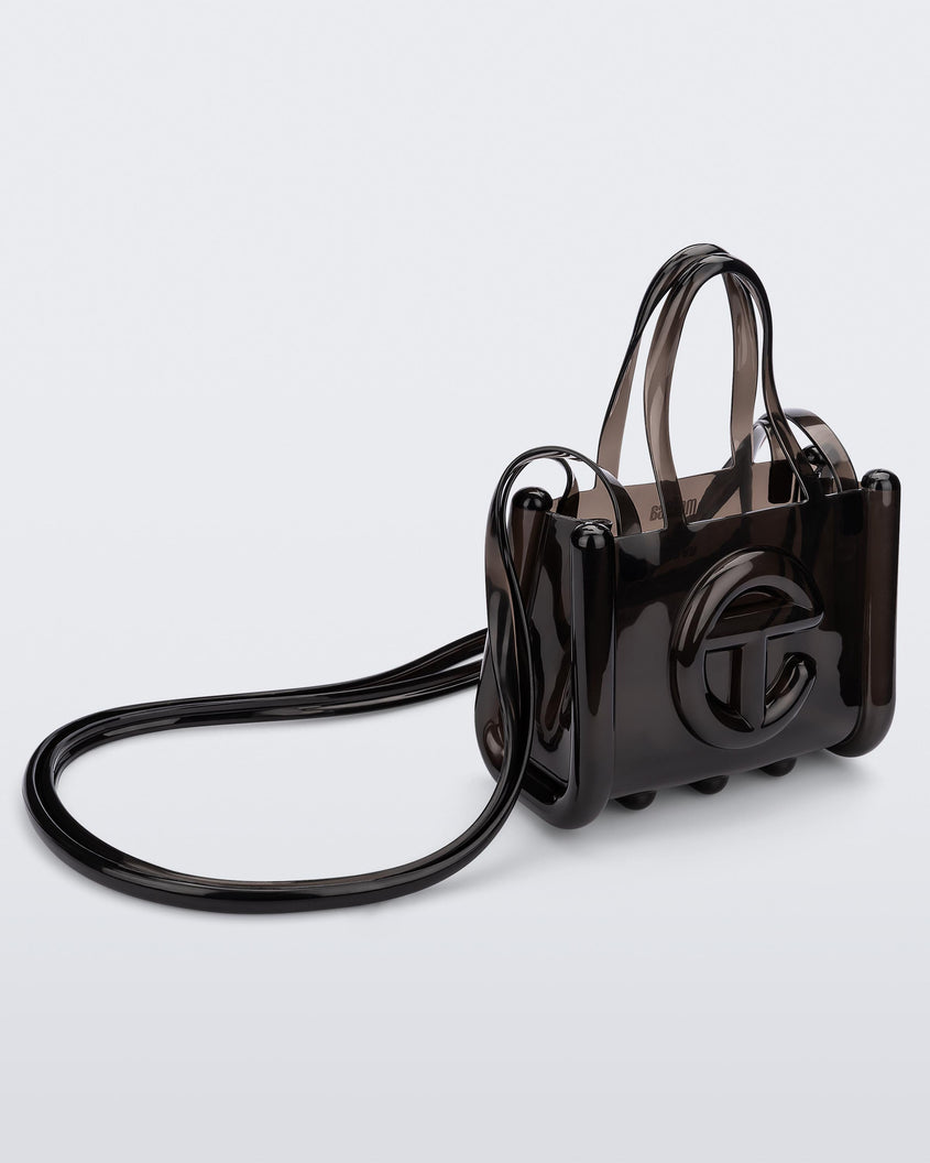 Angled view of a black small Melissa Jelly Shopper bag + Telfar bag with a handle and straps.