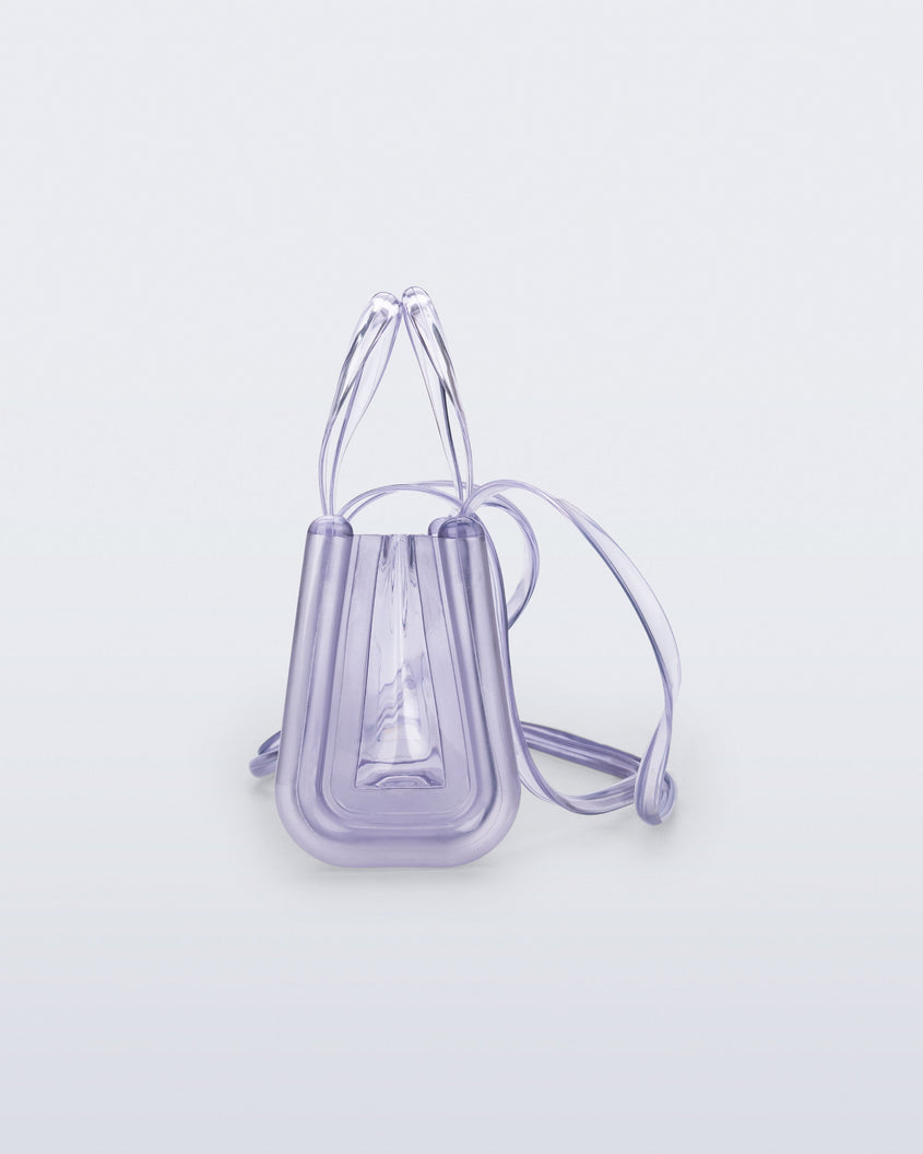 Side view of a clear Melissa Small Jelly Shopper + Telfar bag with handles and a body strap